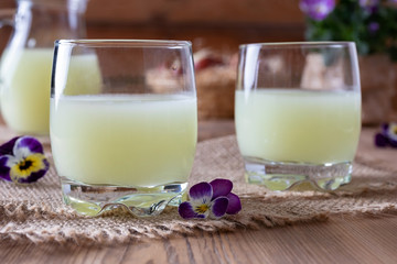 Two glasses of fresh whey with pansy flowers