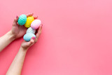 Colorful Easter eggs and paint for celebration on pink background top view mock up