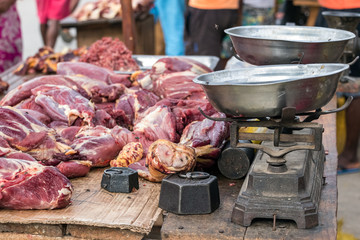 Raw meat next to a bascule and flies around, outdoors in Toliara.