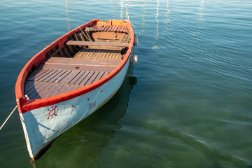Fototapeta na wymiar Close-up of a colored docked boat with green lake water background, Lazise, Lake Garda, Veneto, Italy