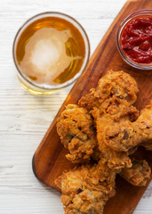 Fried chicken drumsticks with sauce and glass of beer, top view. Overhead, from above. Selective focus.