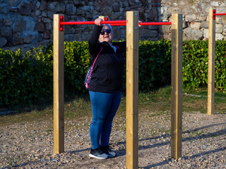 Obraz premium A senior woman with white hair practicing gymnastics in a bio-healthy park