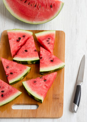 Chopped water melon on bamboo board on a white wooden table, high angle view. Summer food.