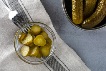 Pickled gherkins with mustard and garlic on a stone rusty background.