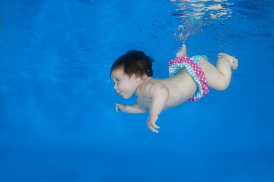 4 months infant learning to swim underwater in a pool, Odessa, Ukraine, Europe
