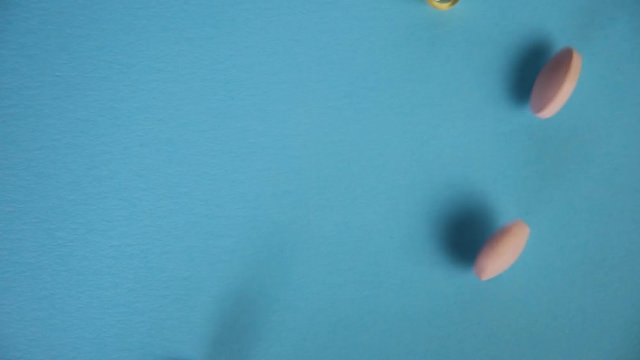 tablets fall on a blue background and roll