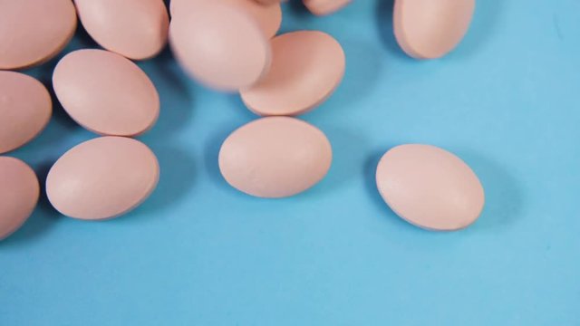 tablets fall on a blue background and roll