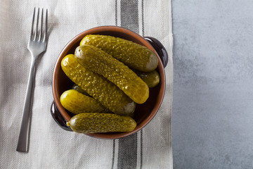 Pickled gherkins with mustard and garlic on a stone rusty background.