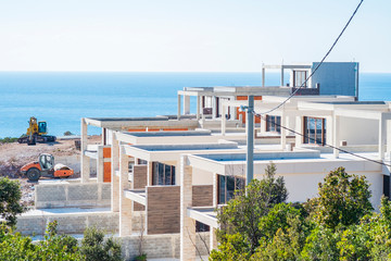 Construction site on a sunny spring day, the construction of a complex of villas on the Adriatic coast. View of an unfinished building