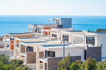 Fototapeta premium Construction site on a sunny spring day, the construction of a complex of villas on the Adriatic coast. View of an unfinished building