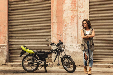 Woman is posing beside old motorcycles - Powered by Adobe