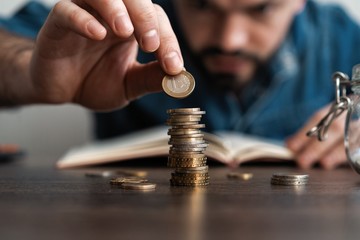 Business man putting a coin on coins stack saving bank and account for his money all in finance accounting concept.