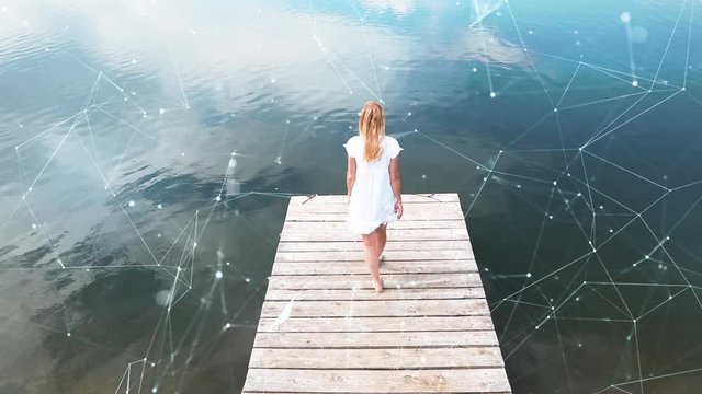 Woman alone on wooden pier at lake with artistic digital lines and dots cyberspace network background.