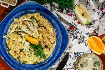 Chicken salad with apple and orange pieces, green curry sauce and sesam seads. Served with white wine and cheeser. Wooden background. Top view