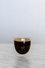 Glass with coffee on table