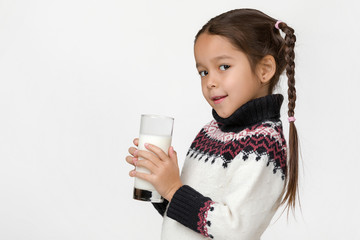 Portrait of cute little child girl holding glass of fresh milk isolated on white