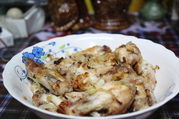chicken fried with onions on a plate close-up
