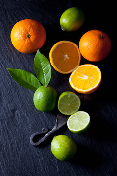 Sliced limes and oranges with an old knife