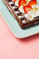 Chocolate waffles with strawberries and whipped cream