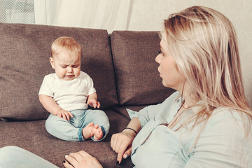 Problems of understanding mother and child. A young woman mom is a nanny and a little disgruntled and angry child. The conflict of a small child with a mother or nanny.
