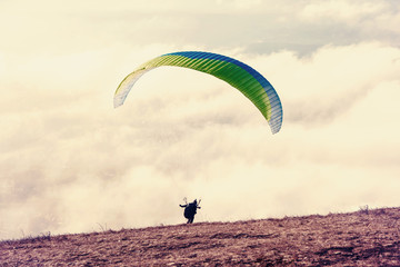 A paraglider with a run-up takes off on a paraglider