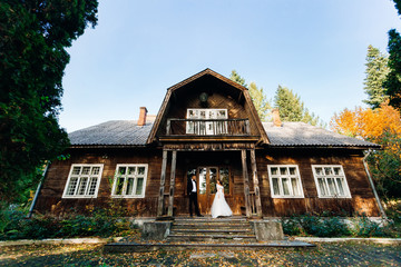 newlyweds on the porch of a wooden building. building with stair
