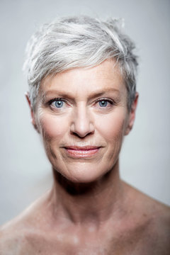 Portrait of mature woman with short grey hair and blue eyes
