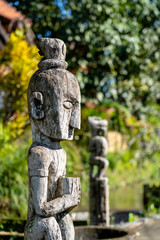 Balinese ancient wooden statue on street in Ubud, island Bali, Indonesia. These figures of the gods protect the house from evil spirits. Closeup