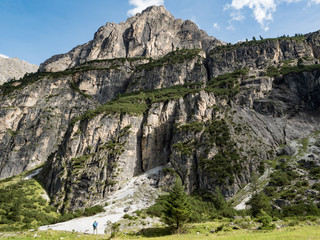Fototapeta na wymiar Mountain landscape with tiny figure of hiker, the Pinnistal valley branches off from the Stubai valley, Stubai Alps, Tyrol, Austria, Europe