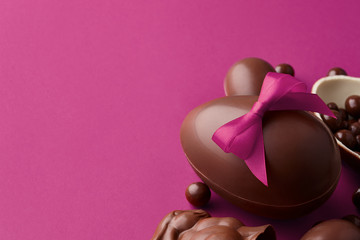 Fototapeta premium Easter composition with chocolate eggs and bunny on purple background, holiday concept