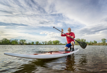 senior male paddler on SUP paddleboard