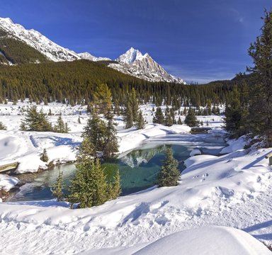 Beautiful Landscape Scenery with Distant Snowcapped Mountain Peaks and Springtime ice melting on Blue Lakes of Ink Pots above Johnston Canyon, Banff National Park Canadian Rockies