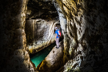 Man exploring smale cave with water in national park Rosandra