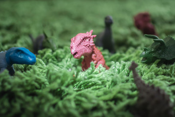 Toy dinosaurs in high grass miniature wild life