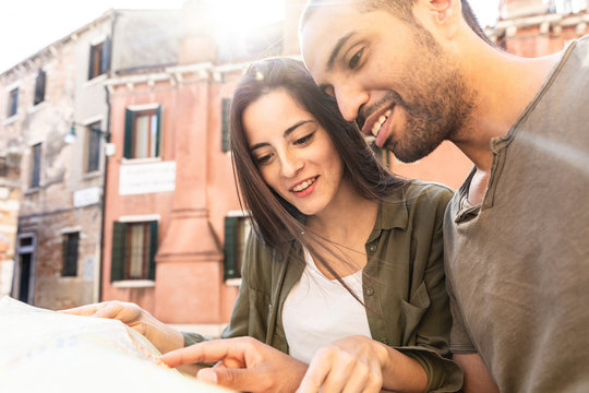 Italy, Venice, young couple looking at map in the city