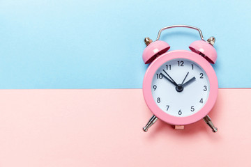 Ringing twin bell vintage classic alarm clock Isolated on blue pink pastel colorful trendy background. Rest hours time of life good morning night wake up awake concept. Flat lay top view copy space