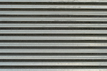 Metal wall texture, background. Sheet of ribbed galvanized metal for building structures. Surface has horizontal protruding ribs for stiffness