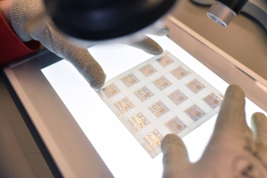 Close-up of woman working on the quality control in the manufacturing of ceramic circuit boards for the electronics industry