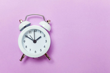 Ringing twin bell vintage classic alarm clock Isolated on purple violet pastel colourful...