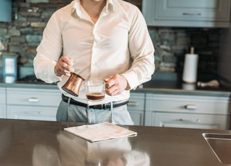 charges groom. waiting for the bride. Man makes coffee in the kitchen in the house of mountains