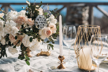 Luxury decorated table and wedding cake for a romantic date. Wedding details: tablecloth, candles, plates, glasses, near a mountain river on background. Wedding, calligraphy vintage, top view.
