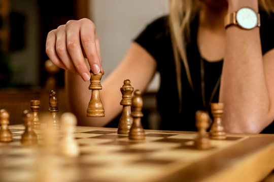 Close-up of a woman's hand moving a chess piece