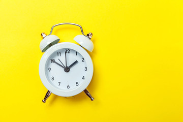 Ringing twin bell vintage classic alarm clock Isolated on yellow colourful trendy modern...