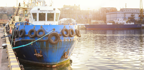  The tug is at the pier in the sea port. Panoramic view on  sea port