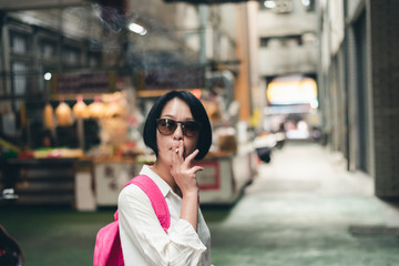 Fototapeta premium Asian woman traveling and smoking