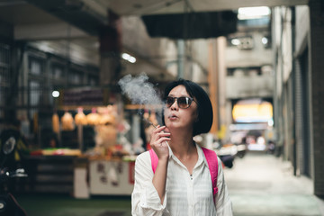 Obraz premium Asian woman traveling and smoking