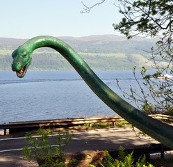 peeking head and neck of the monster on the background of nature