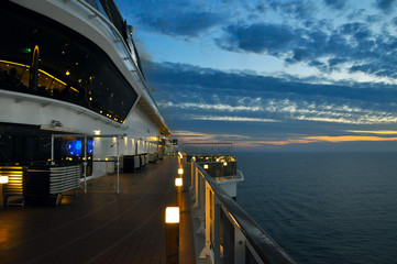 the deck with the lights of a cruise ship on a background sunset