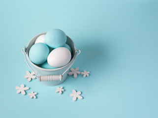 Series of eggs painted white and blue, in a small pail, buctet. Spring and Easter holiday concept.