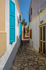 Old narrow greek island streets with traditional white buildings.